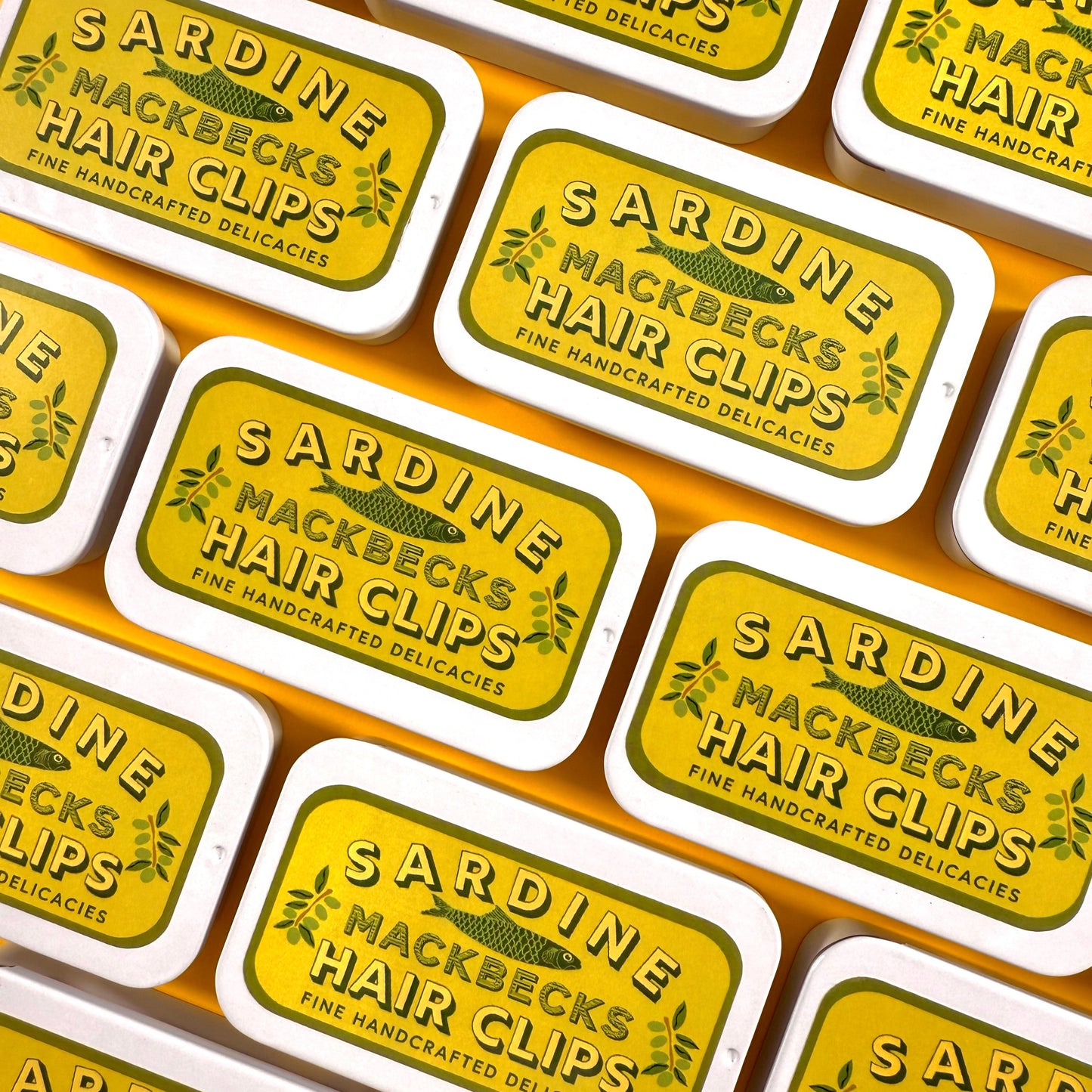 Multiple packages of Sardine Mackbecks Hair Clips on a yellow background