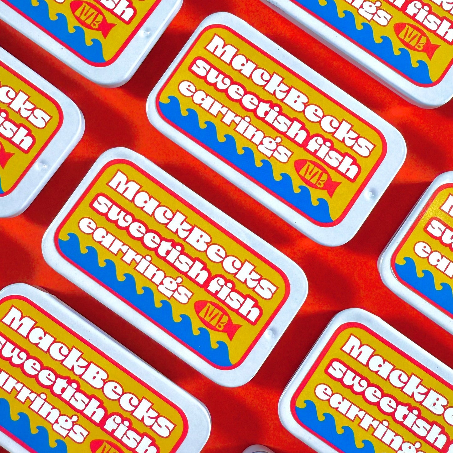 Multiple packages of MackBecks sweetfish earrings on a red background