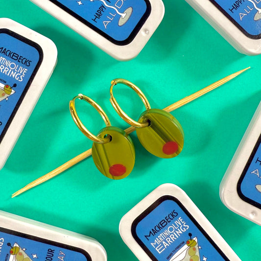 Olive earrings in a collectible martini themed MackBecks tin on a green background.